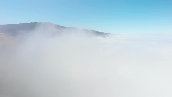 Drone rises up through cloud bank in Big Sur Mountains