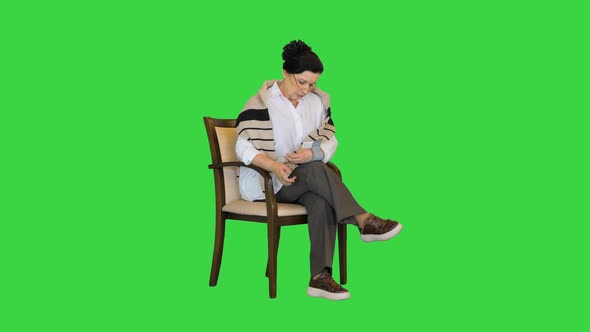 Senior Woman Measuring Her Blood Pressure on a Green Screen Chroma Key alt