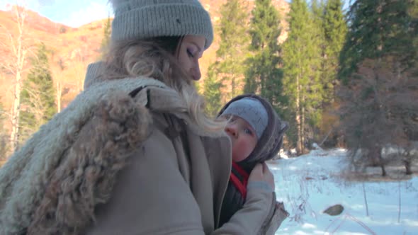 Mother Carry Her Infant Son in a Bay Carrier During Mountain Hiking