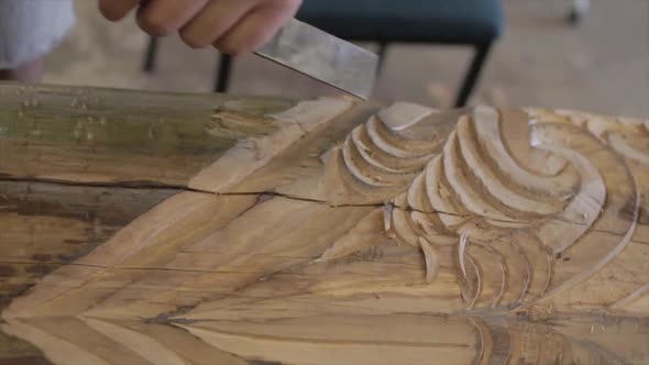 Closeup in slow motion of a carpenter sculpting tinder in a traditional maori way. alt