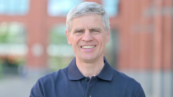 Outdoor Portrait of Middle Aged Man Showing Thumbs Up alt