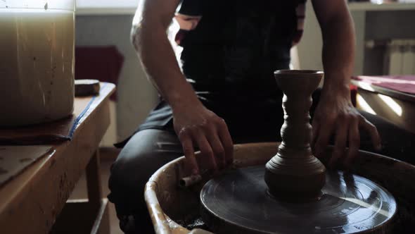 The Potter Cuts the Finished Product of the Vase From the Potter's Wheel alt