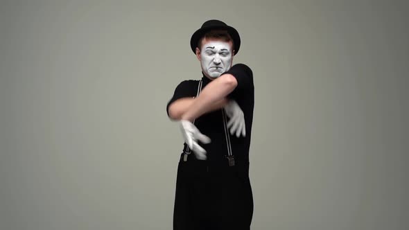 Portrait of Offended Unhappy Male Mime Folding Hands on Chest and Looking Disgruntled at Camera alt
