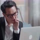 Close Up Of Asian Businessman In Jacket And Shorts Being Tired While Working With A Laptop At Home - VideoHive Item for Sale