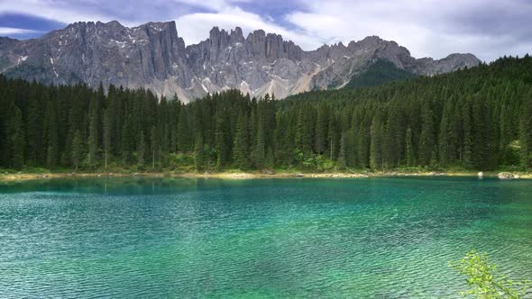 Karersee Lake or Lago Di Carezza, Italy. Wind Blowing on Waters of the Lake. A Pine Forest alt