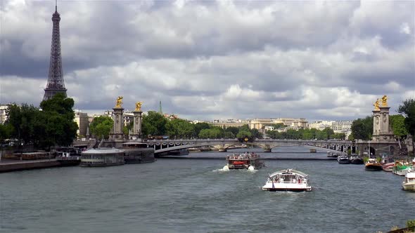 The Eiffel Tower, Pont Alexander III Bridge and tourist boats on the Seine River, Paris, France.