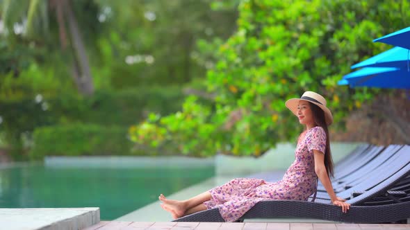 Young asian woman enjoy around outdoor swimming pool for leisure alt