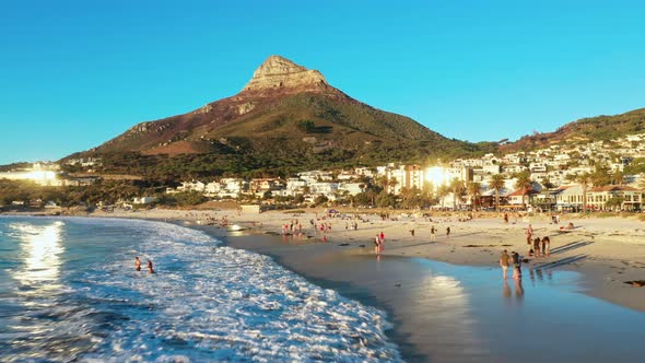 People Enoying Their Time on Camps Bay Beack While the Sun is Starting to Set