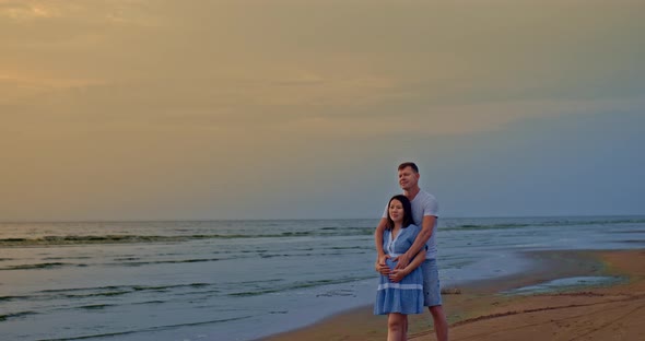 Couple in Love Stands on the Seashore and Looks Into the Distance