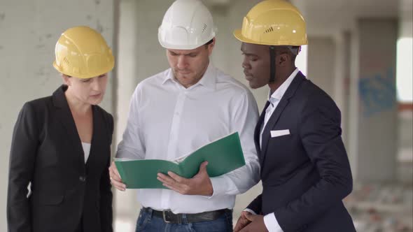 Team of Architects Comparing Housing Project with the Building alt