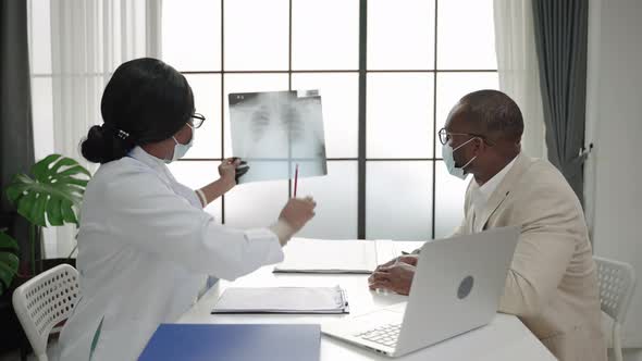 african american female doctor is consulting a black man on treating thorax