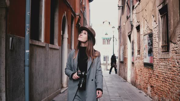 Attractive Happy Professional Female Photographer Walking with Camera Smiling Along Beautiful Old alt