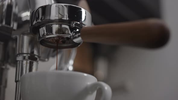Low Angle Shot of Coffee Extraction with Naked Portafilter Into Cappuccino Cup alt