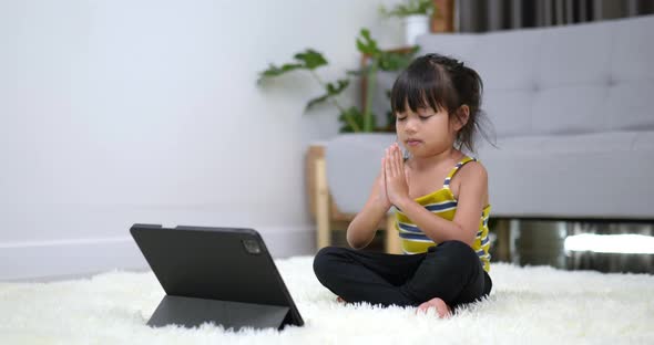Asian cute girl sitting on carpet in meditation pose alt