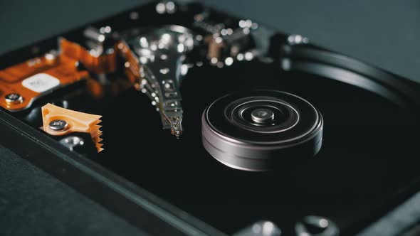 Opened Hard Disk Drive with Spinning Platter. Move of Writing Magnetic Head alt