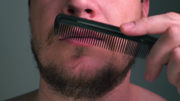 Man Combs His Mustache with a Comb Close-up