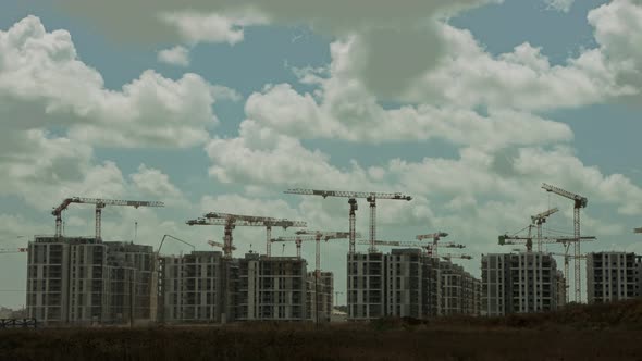 Timelapse of a large construction site with many cranes working over buildings alt