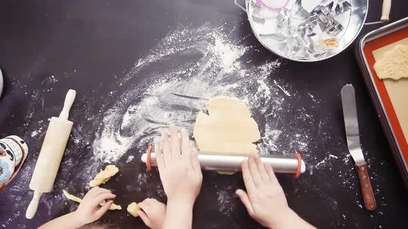 Flat lay. Mother and daughter baking sugar skull cookies for Dia de los Muertos holiday. alt