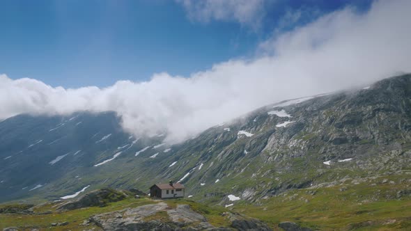 Ride Near the Picturesque Mountain Landscape of Norway, Drive Past a Lone Wooden House alt