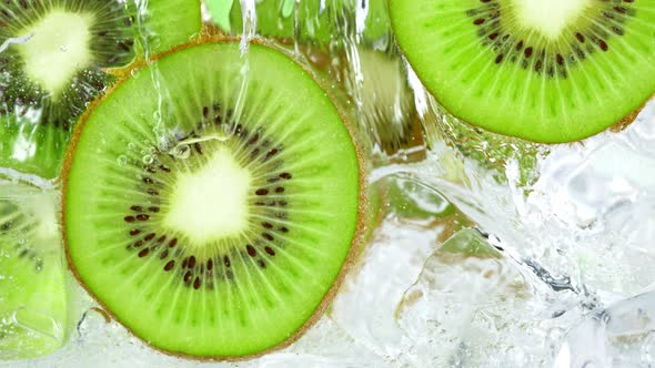 Super Slow Motion Shot of Pouring Water on Sliced Kiwi and Ice Cubes in Glass at 1000 Fps alt