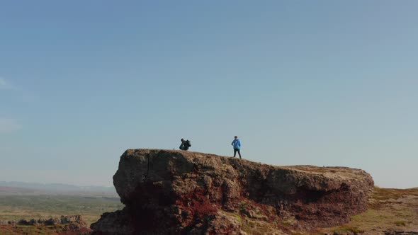 Landing Drone View of Two Climbers Backpackers Feeling Free Top of Hill in Iceland alt