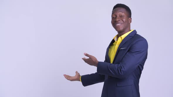Young Happy African Businessman Showing Something To the Back alt