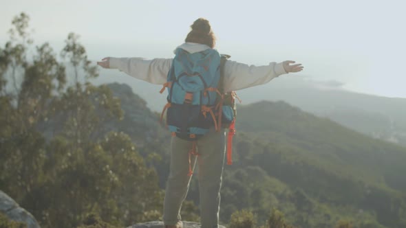 Back View of Female Tourist Standing at Mountain Top