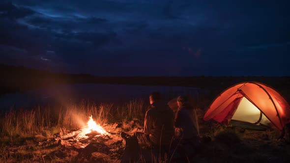 Timelapse of Unrecognisible Couple at Night Camping and Flame Near Pond