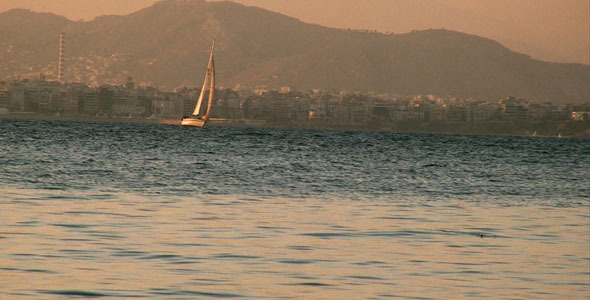 Sailboat Travels in front of a City
