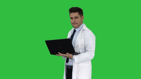 Cheerfull doctor with laptop laughing after giving a serious alt