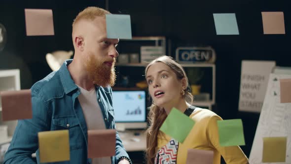 Young Businesswoman Discussing Ideas with Male Colleague in Hipster Office alt