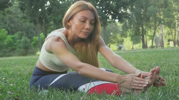 Gorgeous Athletic Woman Stretching Outdoors Smiling To the Camera