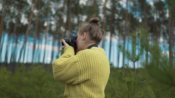 Beautiful Girl Taking Pictures in the Forest alt