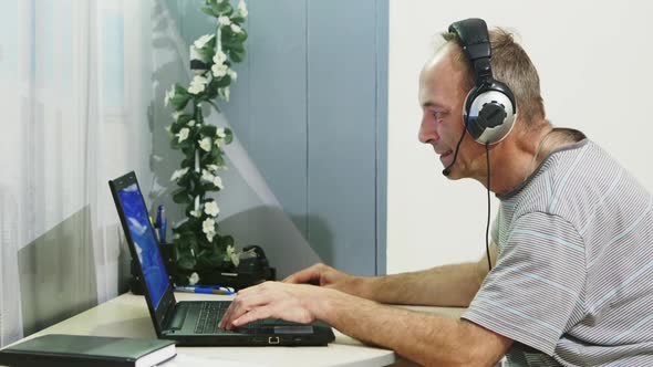 Man Using Laptop Computer at Home. alt