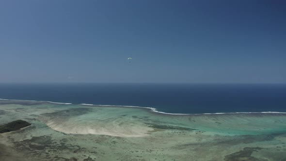 Aerial view of a person doing paragliding among the mountain, Mauritius. alt