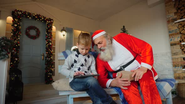Happy Boy Receiving Tablet From Santa Claus.