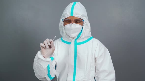 male doctor in protective suit PPE holding Coronavirus(COVID-19) Nasal swab laboratory test