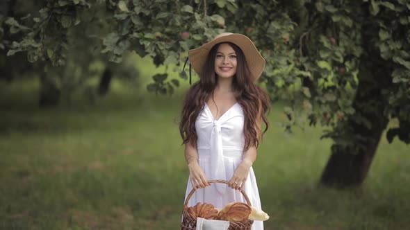 Happy Young Woman in a Straw Hat Walking Ahead