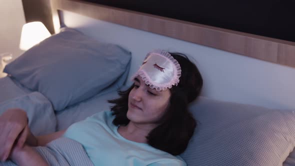 Teen Brunette Girl Puts on a Sleep Mask on Her Face Closes Her Eyes and Sleeps at Night the Girl Has
