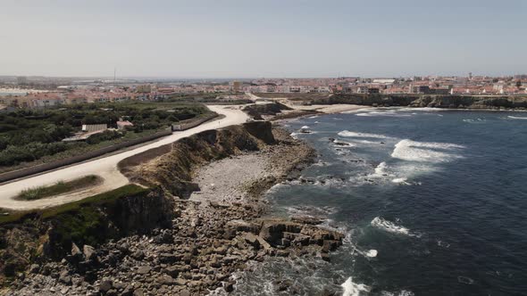 Drone flying over rocky coast of Peniche in Portugal. Aerial forward descending