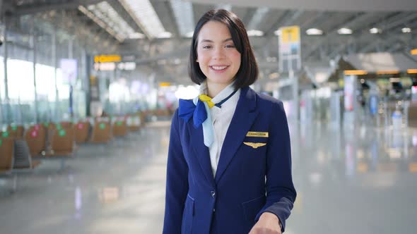 Portrait of Beautiful and attractive Caucasian flight attendant staff stand with smile in airport. alt
