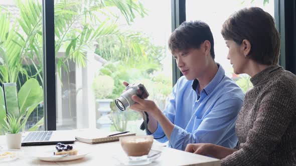 Photographer showing photo on the camera alt