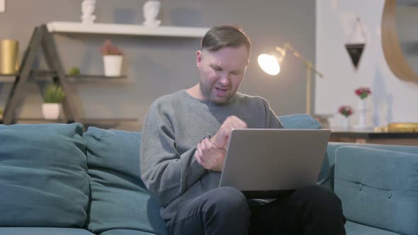 Casual Manwith Laptop Having Wrist Pain on Sofa alt