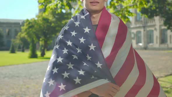 Unrecognizable American Student Wrapping Himself in National Flag. Portrait of Young Man Posing on alt