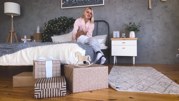 Mother's Christmas Mood with Her Child, Near the New Year Tree. Winter Holidays. alt