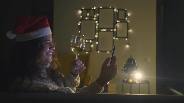 Brunette Holds Champagne Wineglass and Talks on Video Call