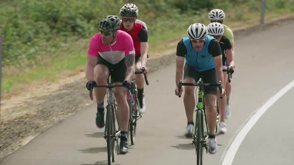Tracking shot of a group of cyclists on country road.  Fully released for commercial use.