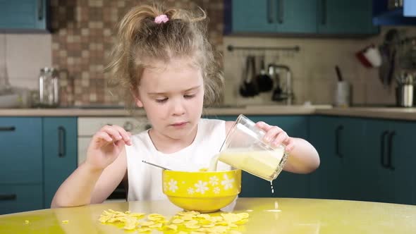 little girl pouring milk  into bowl of corn flakes and eating oatmeal cereal alt
