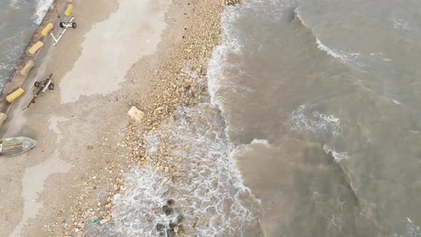 Aerial Top Down Shot Of Small Waves Hitting The Sand In Marsaxlokk Malta alt