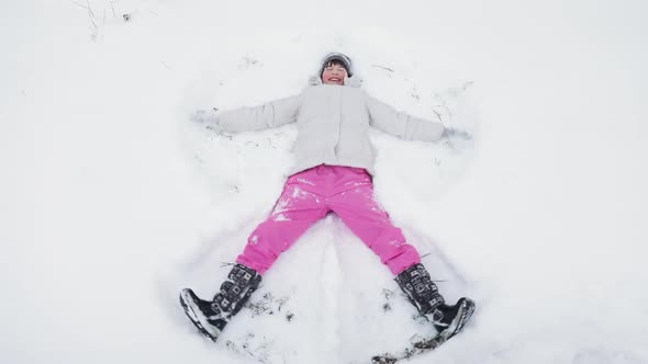 Happy Cute Little Girl Making Snow Angel alt